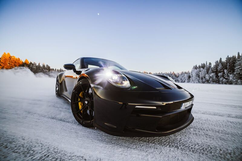 Czarne Porsche 911 na lodzie w mroźnym błękicie poranka