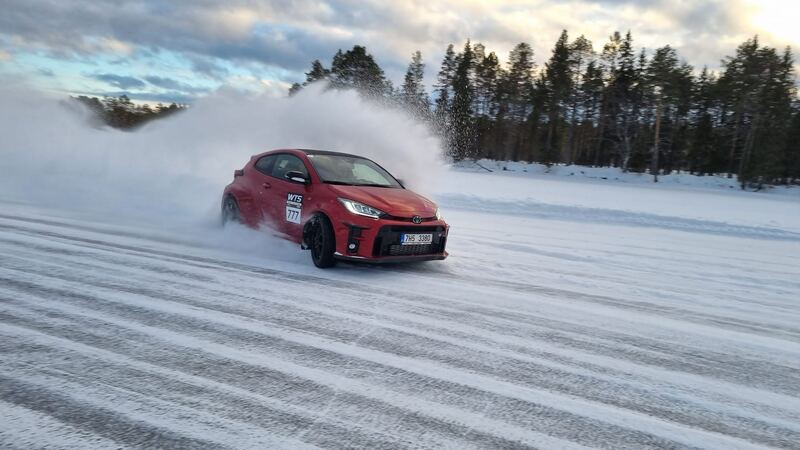 Czerwona Toyota GR Yaris w poślizgu, tuman śniegu spod kół