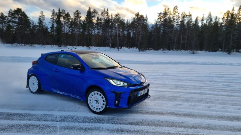 Niebieski hot hatch w poślizgu na lodowym torze