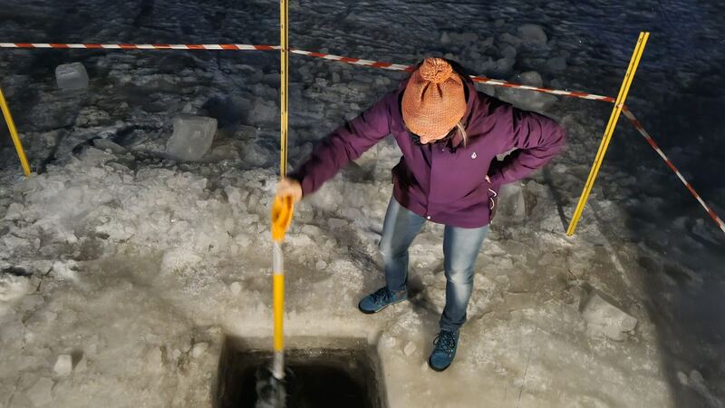 Uczestnik nad przeręblą wyciętą w lodzie jeziora