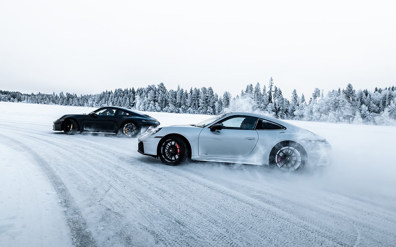 Dwa Porsche 911 w równoległym poślizgu na lodowym torze