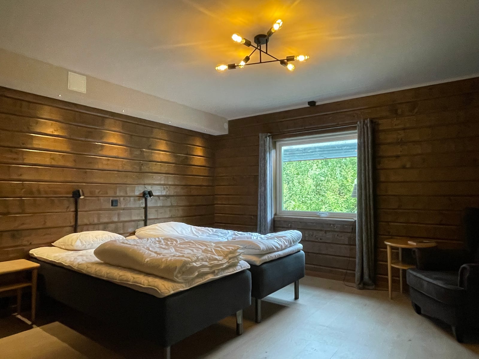 Pokój dwuosobowy w Åkersjöns Fjällhotell — drewniane ściany i okno na las