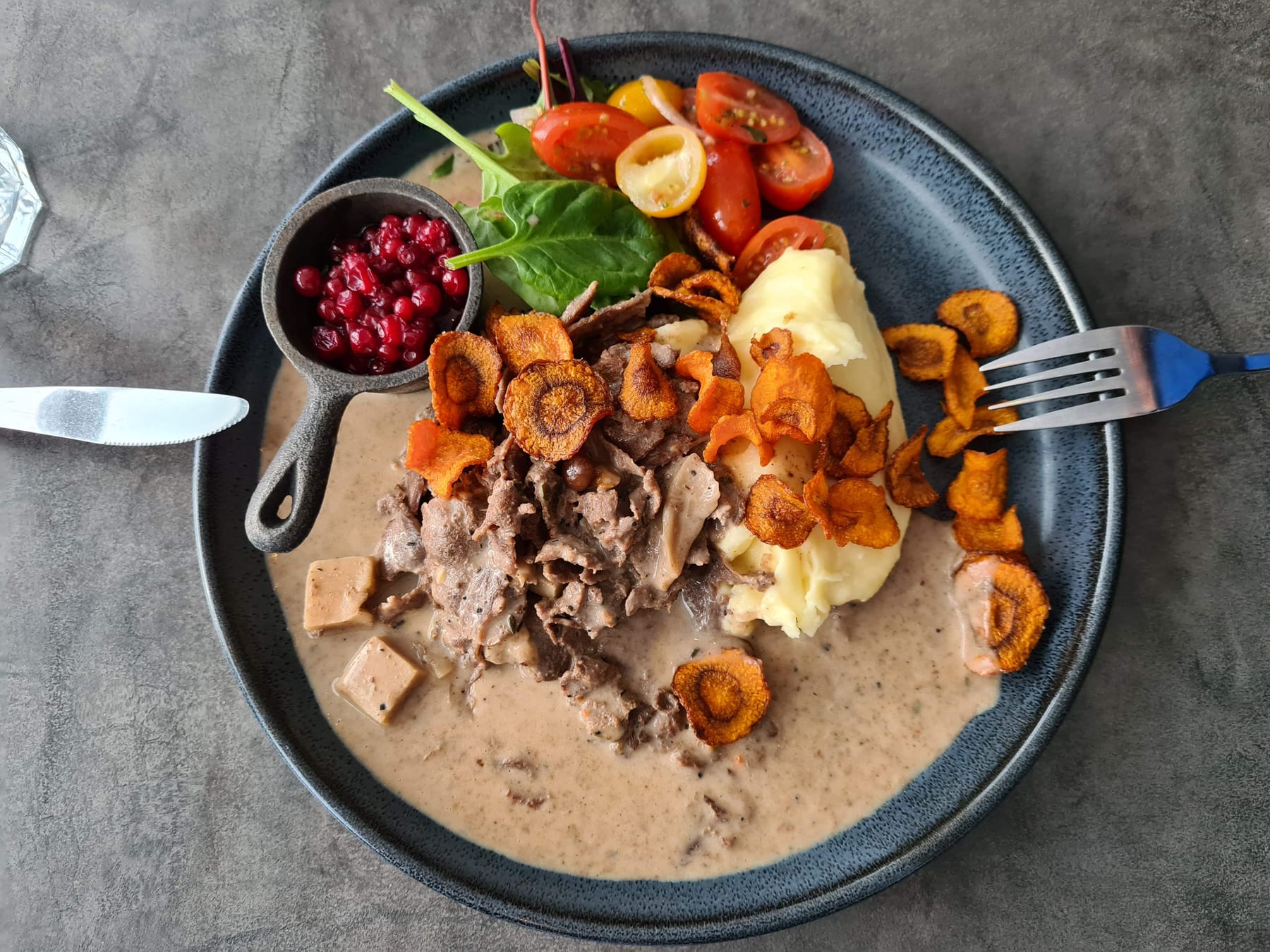 Talerz z lokalnym daniem: gulasz, purée, borówki i smażone kurki